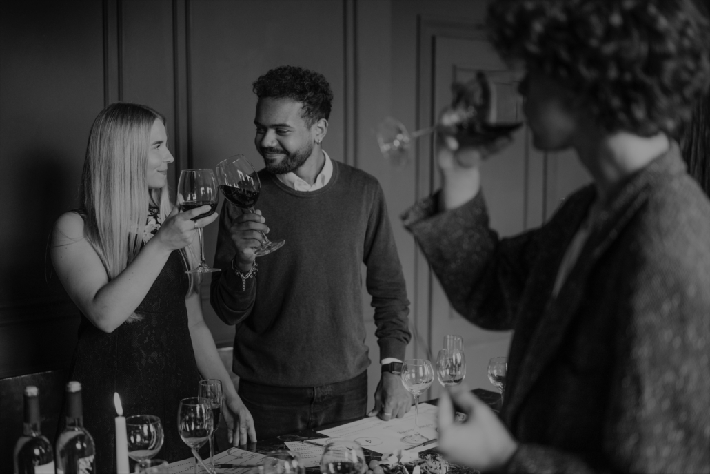 Homem e mulher sorrindo tomando vinho